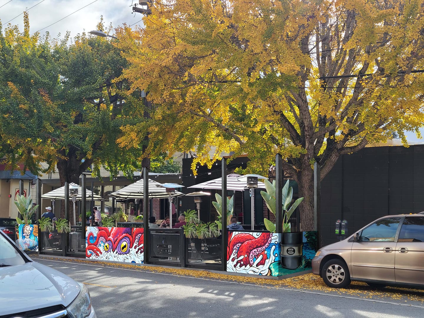 Santa Cruz Parklet Parallel Design Render Rendering of Santa Cruz, CA Parklet by Braid.Work Landscape Architecture. Permanent patio seating on a public street with restaurant tables and local art